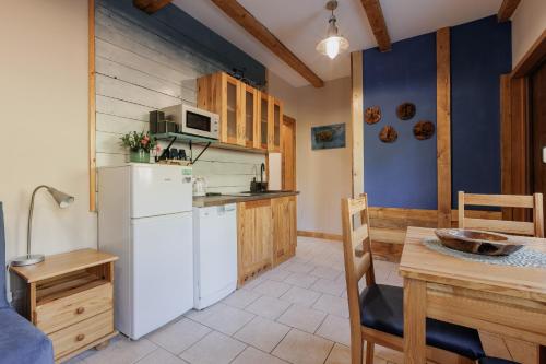 a kitchen with a white refrigerator and a table at Jesteśmy Na Ty - Apartamenty in Lewin Kłodzki