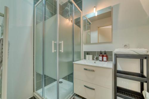 une salle de bain avec une douche en verre et un lavabo dans l'établissement Le Petit Gerland - Agréable à 1 minute du métro B, à Lyon