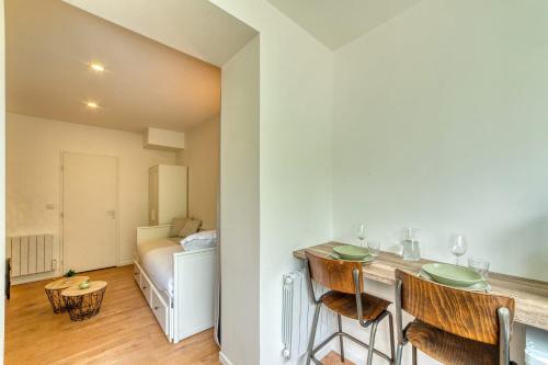 - une cuisine avec un comptoir et des chaises dans la chambre dans l'établissement Le Petit Gerland - Agréable à 1 minute du métro B, à Lyon