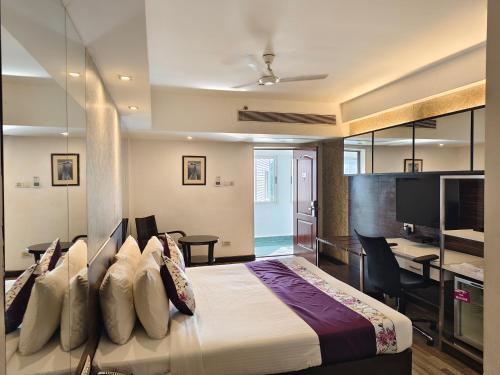 a hotel room with a bed and a desk and a desk at Regenta Place Bangalore, Cunningham Road in Bangalore