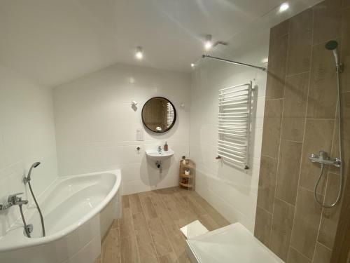 een badkamer met een bad, een wastafel en een douche bij Motel Orion in Piła