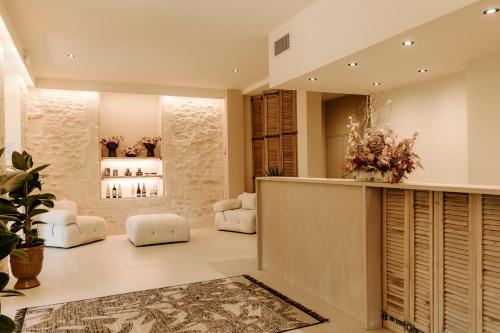 un vestíbulo con muebles blancos y flores en la pared en Soko Hotels-Pont du Gard en Remoulins