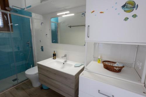 Un baño con lavabo, inodoro y ducha. en La Casetta di Leo - Favignana, en Favignana