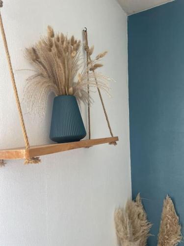 un vase vert assis sur une étagère sur un mur dans l'établissement Spacieuse Maison Familiale proche de la Mer, 11 Vélos à disposition, à Plouhinec