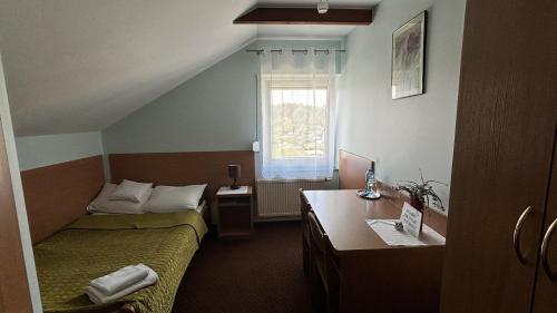 Cette chambre comprend deux lits, un bureau et une fenêtre. dans l'établissement Motel Orion, à Piła