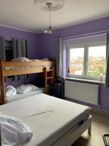 a bedroom with two bunk beds and a window at Soucis au vent 2 in De Panne