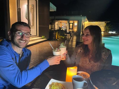 a man and a woman sitting at a table with drinks at XMAN Sunrise Peaks Resort--Free Pick-up in Zhangjiajie