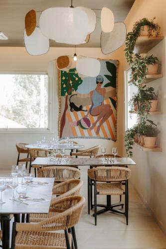 a restaurant with tables and a painting on the wall at Soko Hotels-Pont du Gard in Remoulins