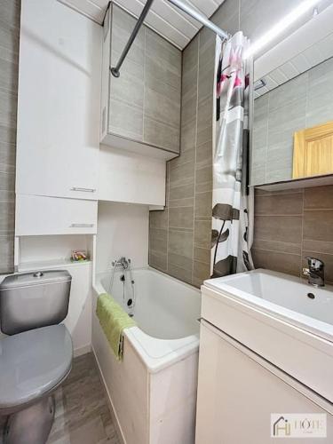 une salle de bain blanche avec des toilettes et un lavabo dans l'établissement Appart 1er Étage, Plage à 50m, à Bray-Dunes