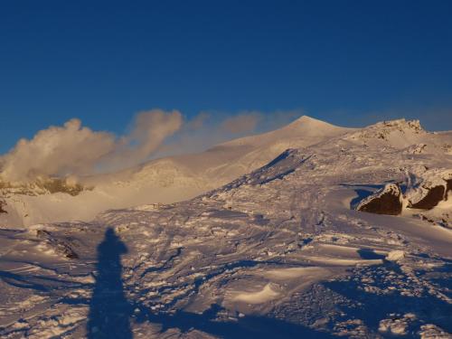 a person standing on top of a snow covered mountain at NORTH GLAMPER 富良野 in Kami-furano