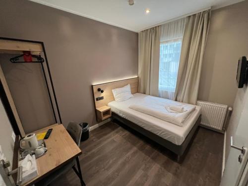 a small room with a bed and a window at JJ Hotel Hannover-City-Pension in Hannover