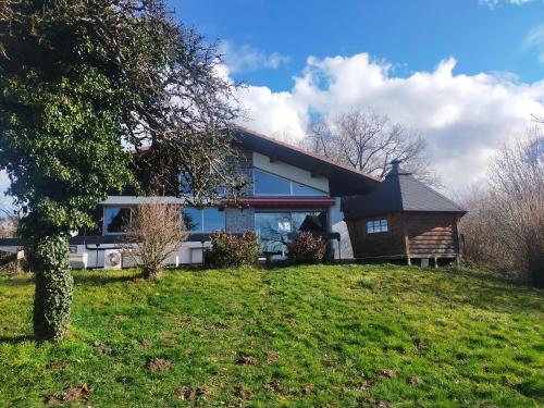 une maison sur une colline herbeuse avec un arbre dans l'établissement Maison au calme, à Marin