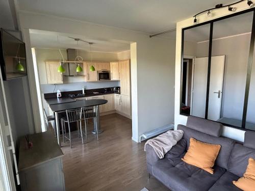 un salon avec un canapé et une cuisine dans l'établissement Appartement Talant, à Talant