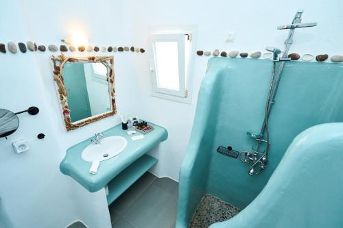 a blue bathroom with a sink and a mirror at Bellissimo Resort in Agios Ioannis Mykonos