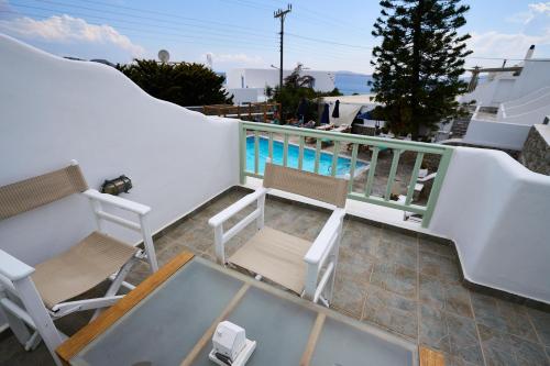 a balcony with chairs and a swimming pool at Bellissimo Resort in Agios Ioannis Mykonos