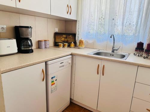 a kitchen with white cabinets and a sink at Estate Tsoukalas with Pool - Perfect for Large Groups Next to Laganas Offering Incredible Greek Hospitality By Villa Mana Gers in Ambelókipoi