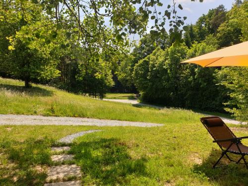 a chair and an umbrella sitting in the grass at Ferienhaus Kellerstöckl Maja in Sumetendorf