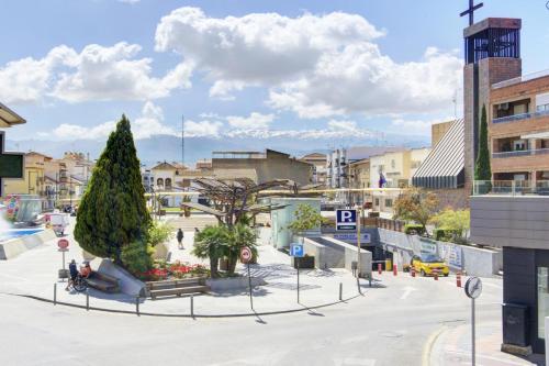 a street in a city with a tree and buildings at Apartamento San Cayetano, By DaiMar in Armilla