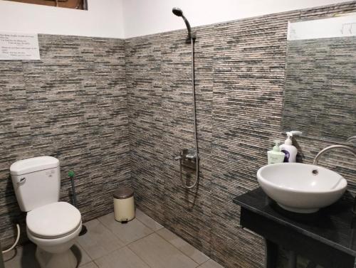 a bathroom with a shower and a toilet and a sink at BONNIE HOMESTAY Mui Ne in Mui Ne