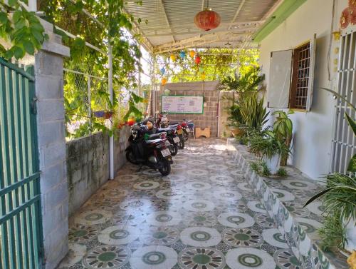 a courtyard with a scooter parked on a tiled floor at BONNIE HOMESTAY Mui Ne in Mui Ne