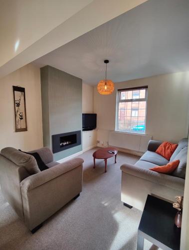 a living room with two couches and a tv at Victorian Semi Detached House behind the High Street in Newton in Makerfield