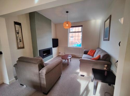 a living room with two couches and a tv at Victorian Semi Detached House behind the High Street in Newton in Makerfield