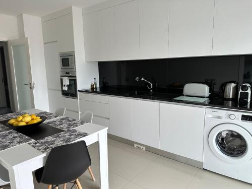 een witte keuken met een wastafel en een wasmachine bij PMDOUROVALLEY in Peso da Régua
