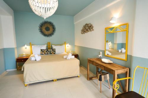a bedroom with a bed and a mirror and a table at Bellissimo Resort in Agios Ioannis Mykonos