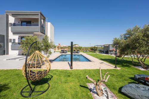 a sculpture in the grass next to a swimming pool at Aspect Luxury Apartments with Pool in Galangádhos