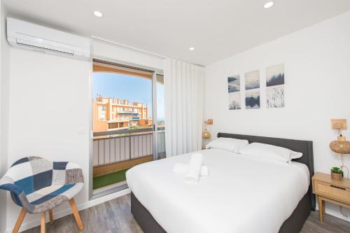 une chambre avec un grand lit et une fenêtre dans l'établissement Monaco à pied - Spacieux appartement - Balcon - CA, à Beausoleil