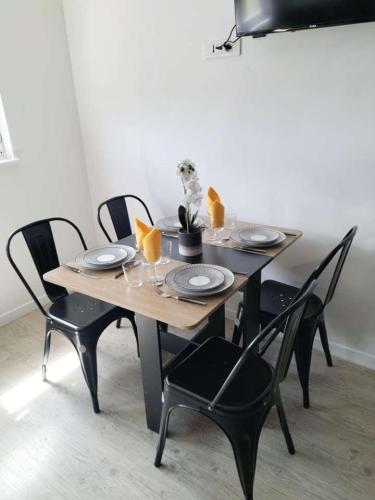 une table en bois avec des chaises noires et une table avec des assiettes dans l'établissement Ô Ciel d'Obernai, à Obernai