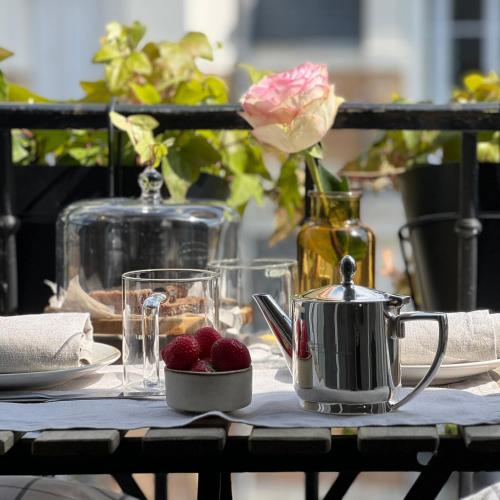 une table avec une bouilloire et des fraises dessus dans l'établissement Michel Ange Casa in Paris, à Paris