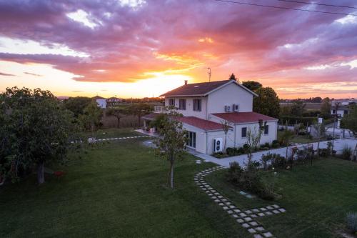 a white house with a sunset in the background at El Patio in San Vito Rimini