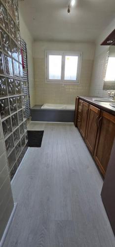 une grande salle de bain avec une baignoire et un lavabo dans l'établissement Maison 3 chambres avec piscine, à Josse