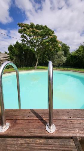 - une piscine avec deux rails métalliques à côté dans l'établissement Maison 3 chambres avec piscine, à Josse