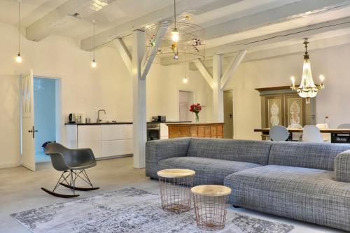a living room with a couch and a table at NordseeEstate - Loft unter Reet mit Sauna in Tetenbüll