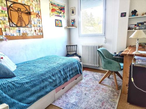 une chambre avec un lit, un bureau et une chaise dans l'établissement La maison du bonheur, à Montreuil