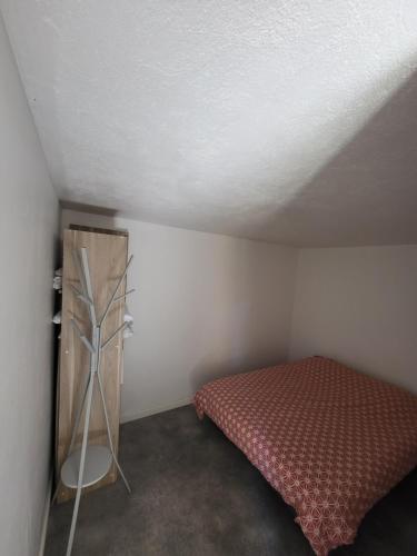 ein kleines Schlafzimmer mit einem Bett im Dachgeschoss in der Unterkunft Jolie T2 indépendant dans une villa in Solliès-Ville