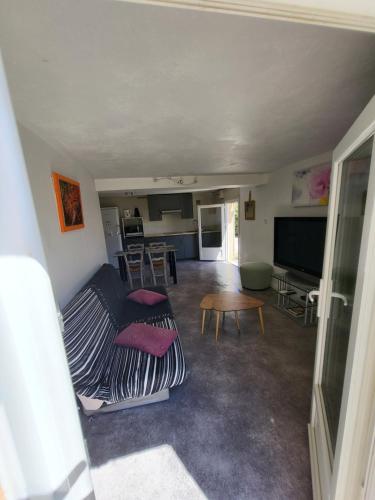 ein Wohnzimmer mit einem Sofa und einem Tisch in der Unterkunft Jolie T2 indépendant dans une villa in Solliès-Ville
