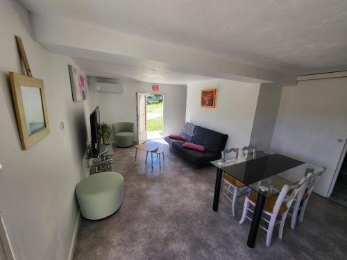 ein Wohnzimmer mit einem Tisch und einem Sofa in der Unterkunft Jolie T2 indépendant dans une villa in Solliès-Ville