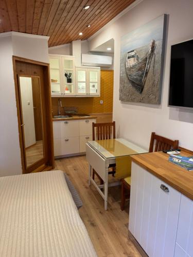 a kitchen with a desk and a table with chairs at Studio Lorena in Mali Lošinj
