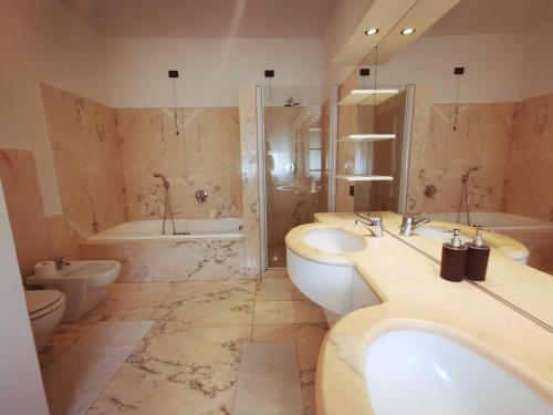 bagno con 2 lavandini, vasca e servizi igienici di Sweet House a Solesino