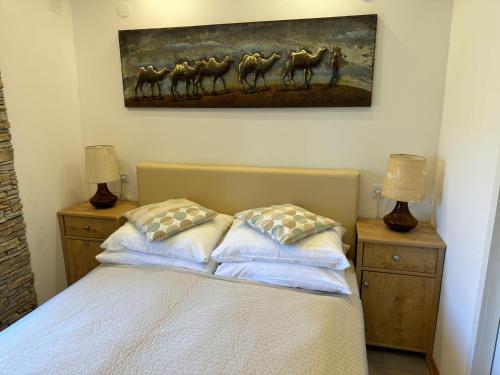 a bedroom with a bed with a painting on the wall at Studio Lorena in Mali Lošinj
