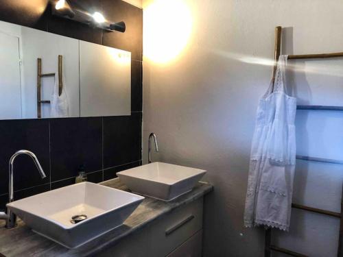 une salle de bain avec deux lavabos blancs et un miroir dans l'établissement Maison avec jardin, à Sainte-Maxime
