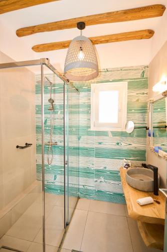 a bathroom with a glass shower and a sink at Bellissimo Resort in Agios Ioannis Mykonos