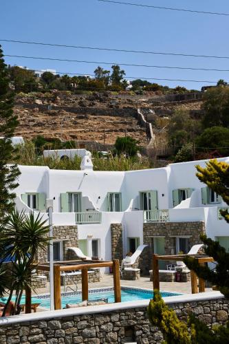 a group of white buildings with a swimming pool at Bellissimo Resort in Agios Ioannis Mykonos