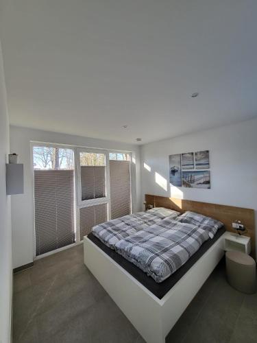 a bedroom with a large bed and windows at Elseblick in Schüttorf