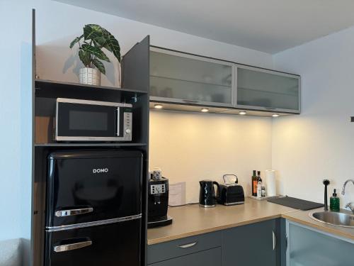 a kitchen with a black refrigerator and a microwave at Central Pearl Apartment in Reykjavík