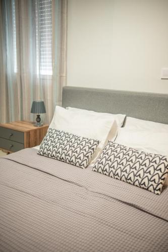 a bed with two pillows on top of it at Kos Cozy Home in Kos