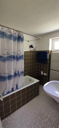 a bathroom with a tub and a shower curtain at Gasthaus Stausee in Innerthal